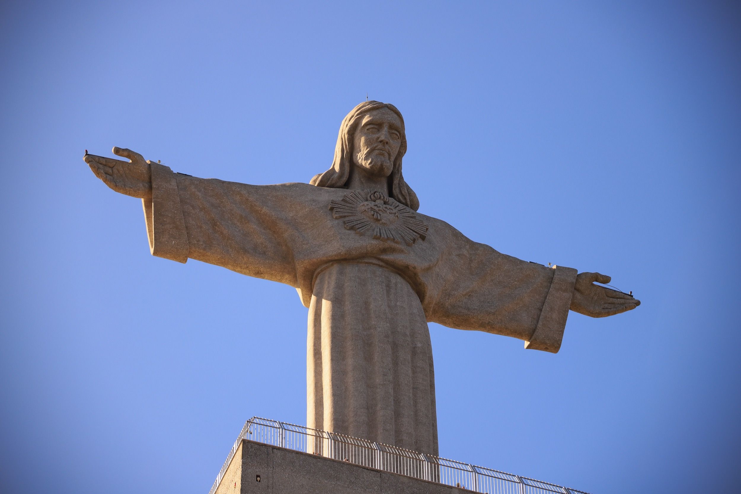 Die ikonische Cristo Rei Statue mit ausgebreiteten Armen über dem Tejo, ein Wahrzeichen von Lissabon und Umgebung.