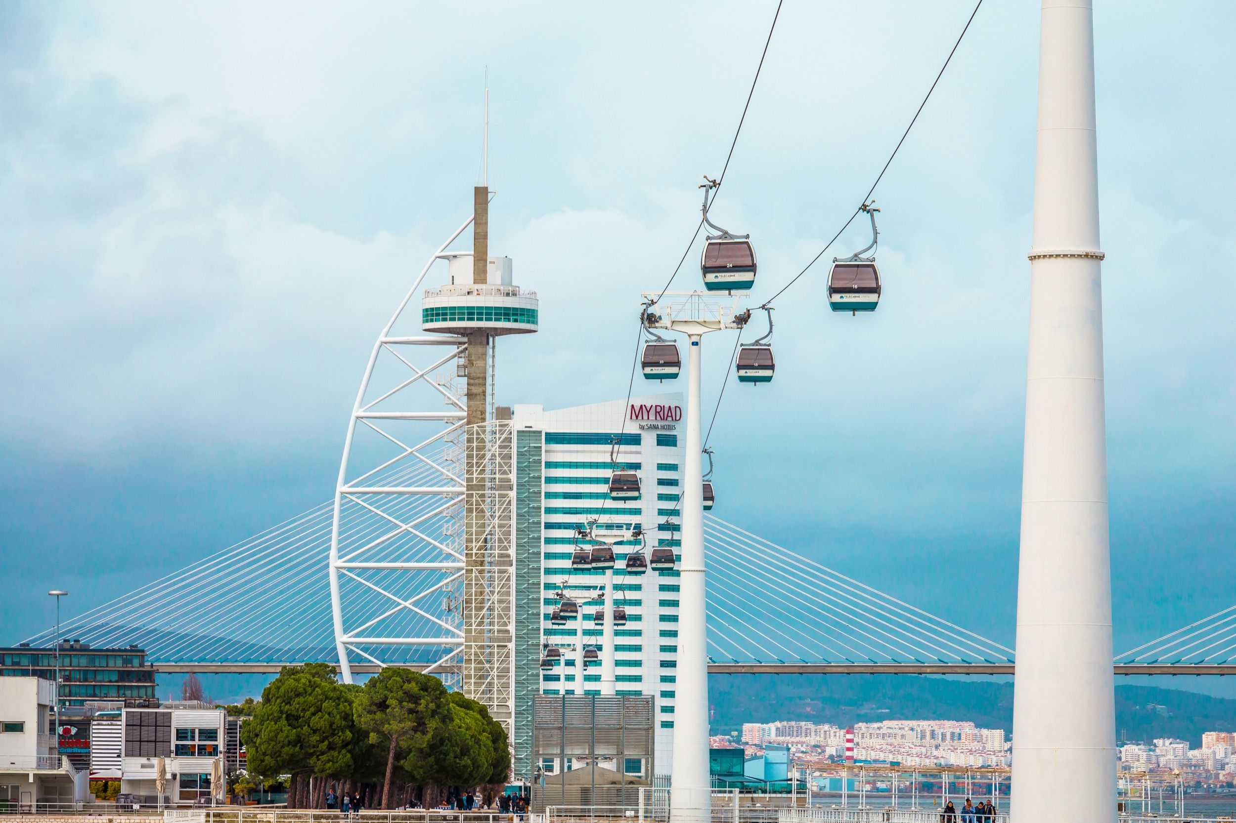 Moderner Park mit Seilbahn (Telecabine) über den Tejo, Oceanário und Vasco-de-Gama-Turm im Hintergrund.