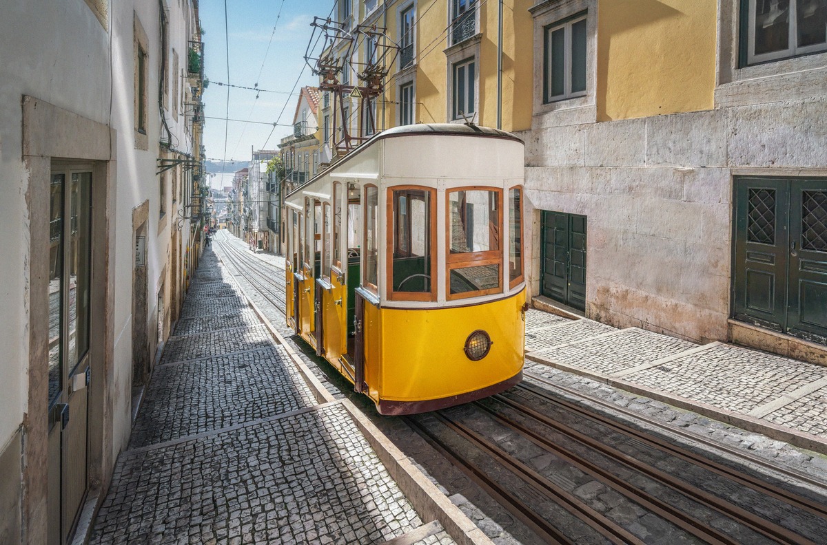 The yellow Elevador da Bica funicular in its steep lane